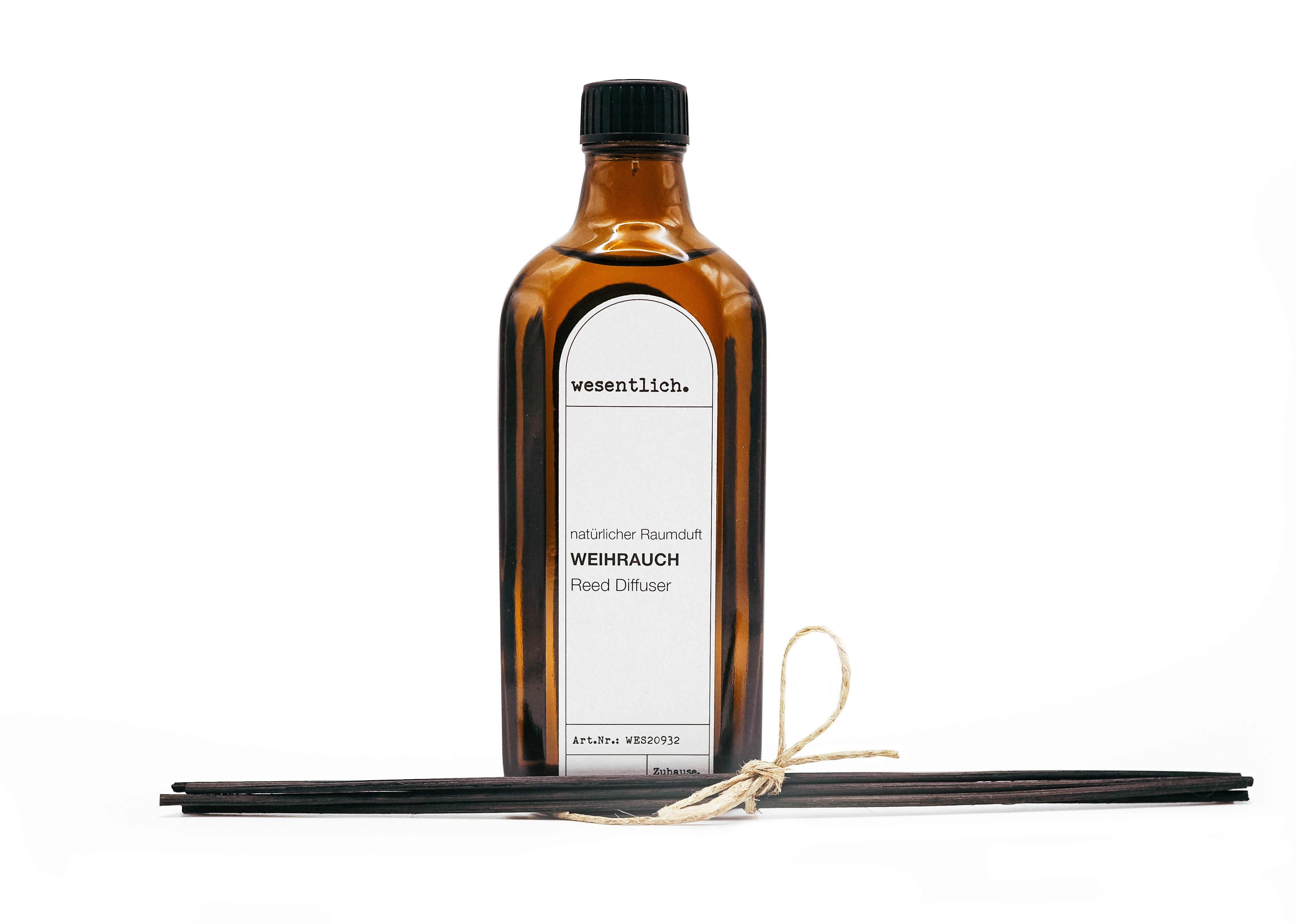 Braune Glasflasche mit schwarzem Deckel und weißem Etikett. Enthält schwarze Kapillarstäbchen, gebunden mit Kordel.