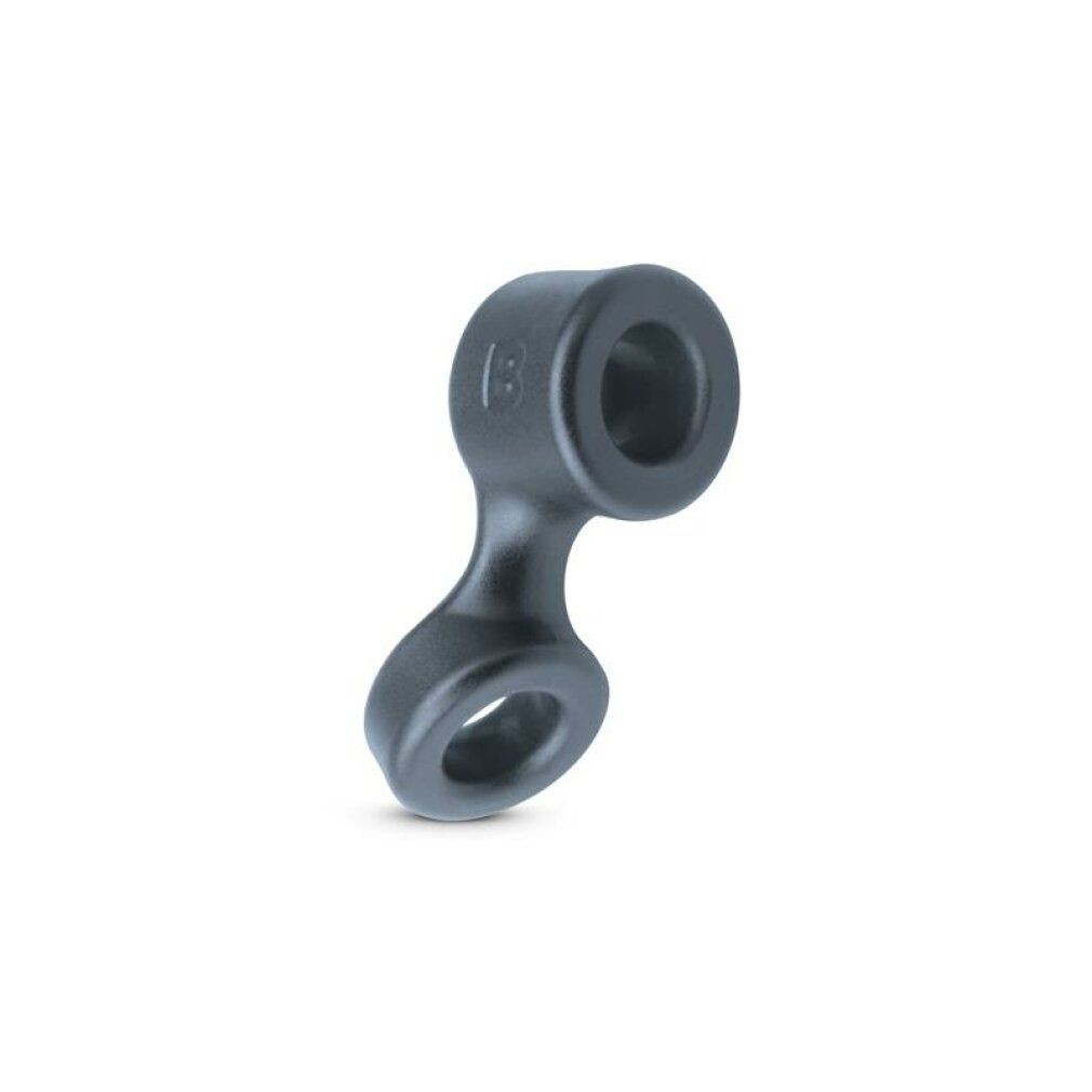 Dunkelgrauer Cockring und Ballstretcher. Zwei Ringe sind durch einen gebogenen Steg verbunden.