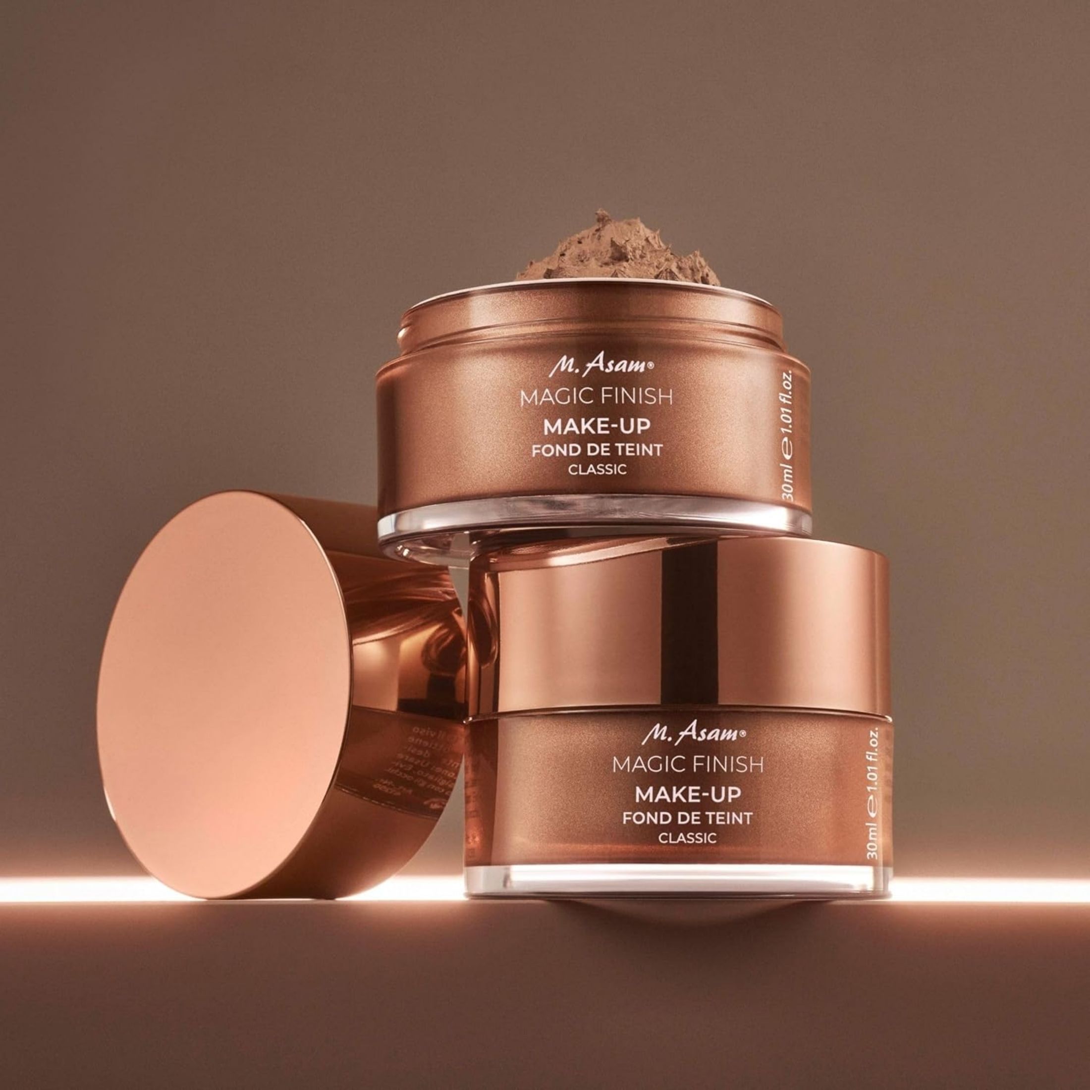 Tre fondotinta mousse M. Asam Magic Finish. Coperchi color rame.