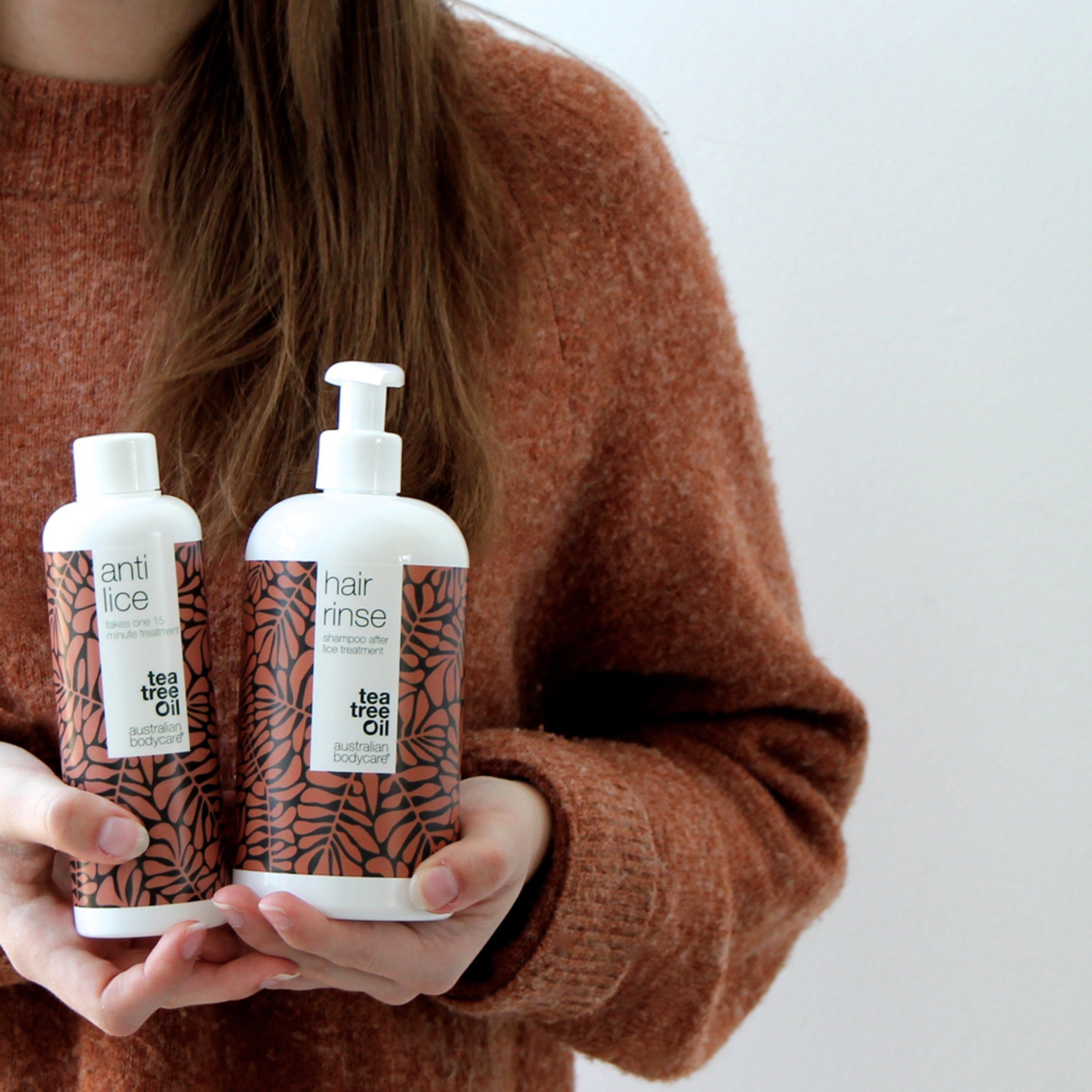 Person hält zwei Flaschen. Aufschrift: anti lice, hair rinse. Marke: Australian Bodycare.