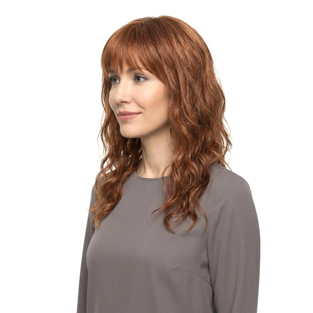 Perücke Kiky von trendhair. Rötlich-braune, gewellte Kunsthaarperücke mit Pony. Seitenansicht einer Frau.