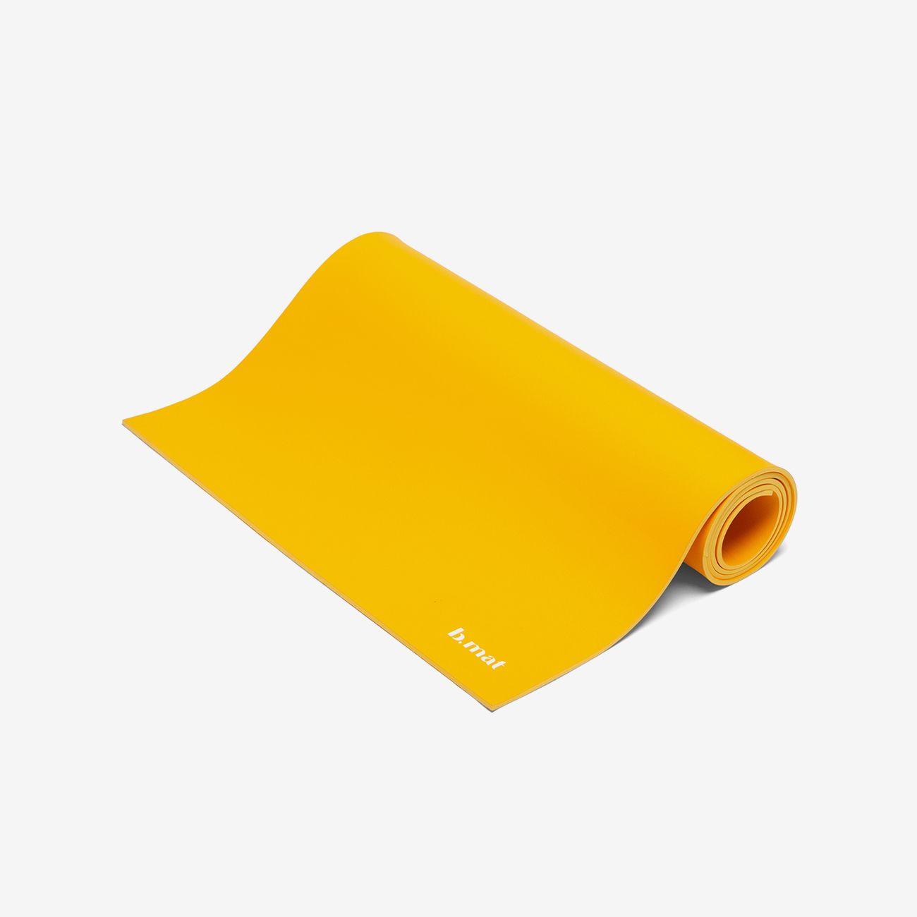 Gelbe Yogamatte, teilweise gerollt. Aufgedrucktes Logo "b mat".