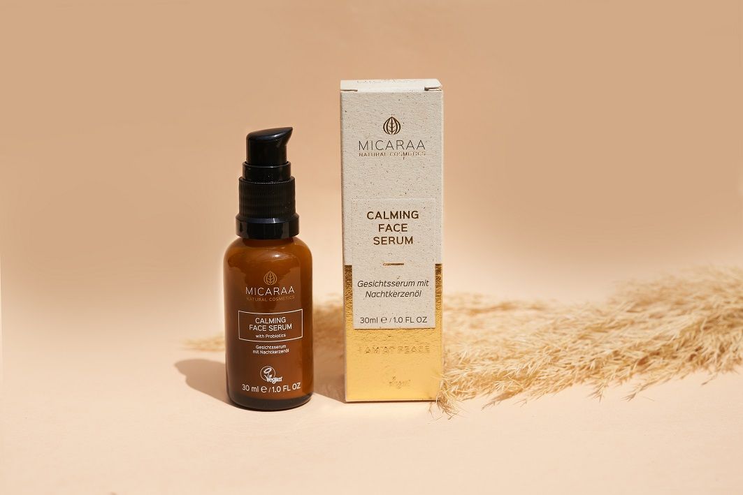 Produkt mit Verpackung. Braune Glasflasche mit schwarzem Pumpkopf. Aufschrift: MICARAA Calming Face Serum. Vegan-Siegel. 30 ml.