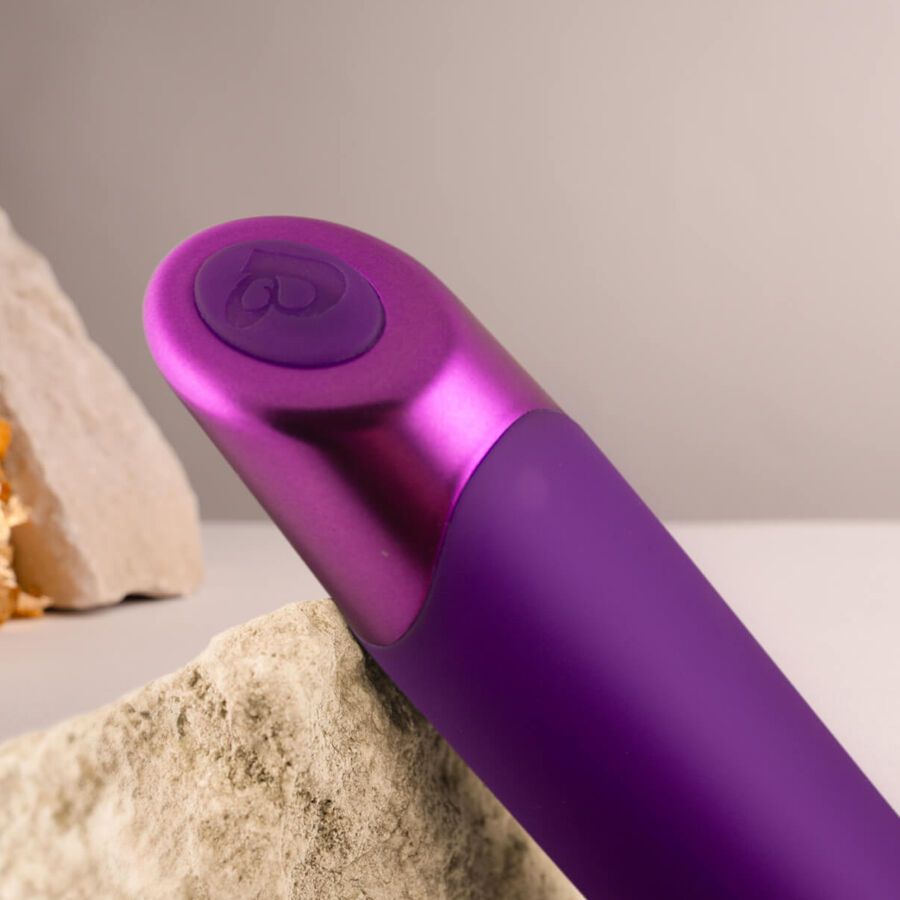 Nahaufnahme eines lila Vibrators mit metallischem Ende. Knopf mit Herzsymbol.