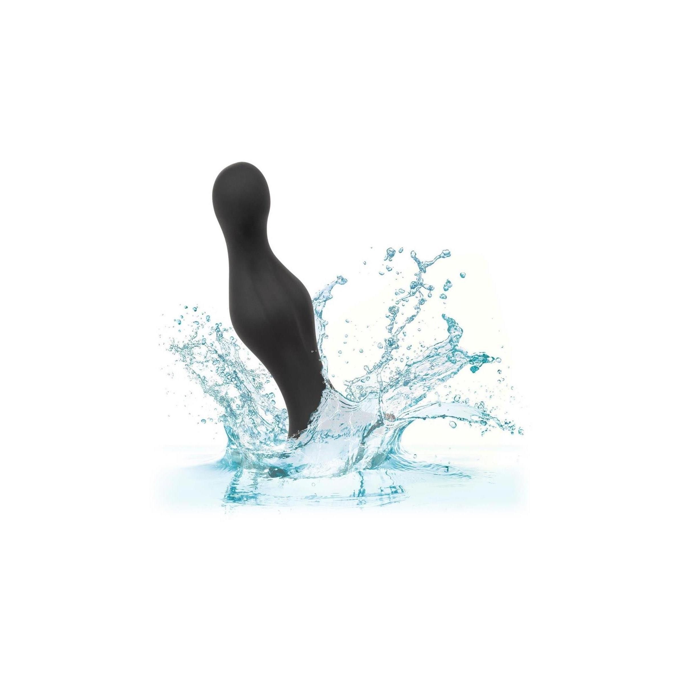 Ein schwarzer Anal-Stöpsel in Wasser. Wasserspritzer umgeben das Produkt.