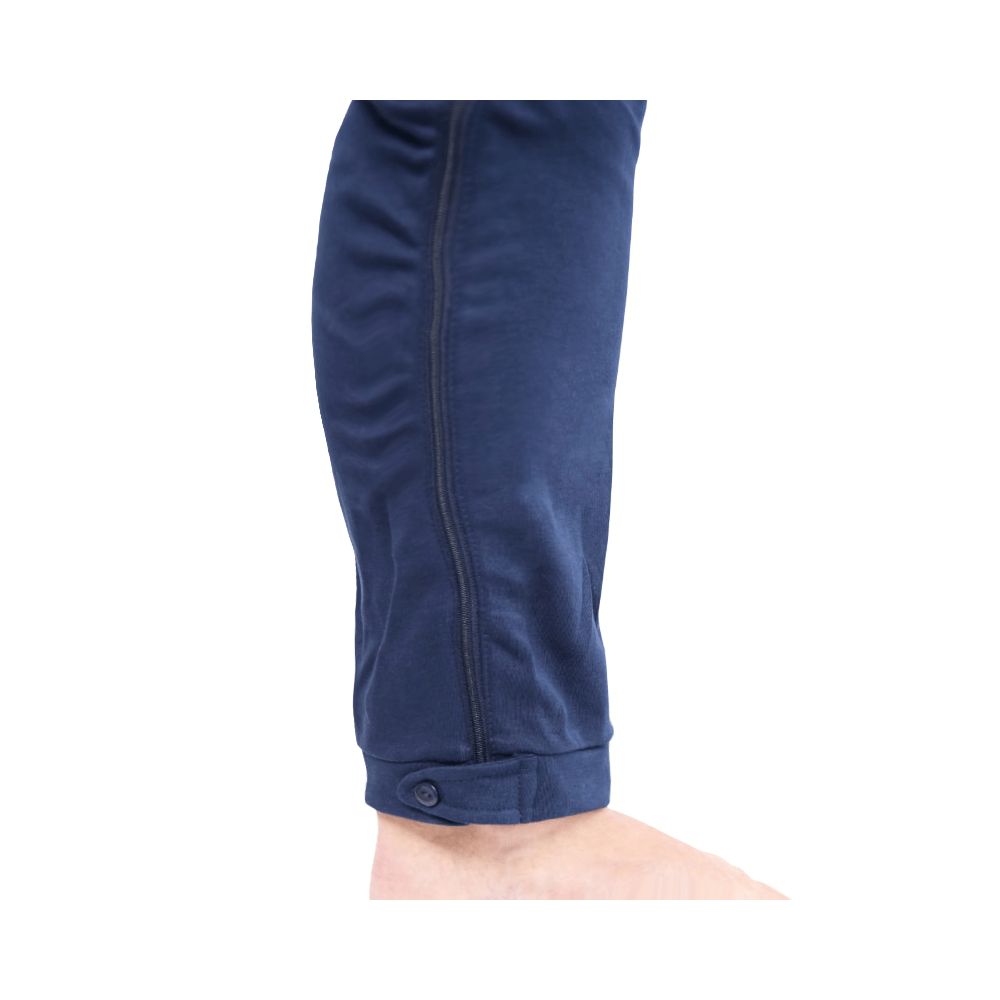 Detailansicht des Pflegeoveralls. Marineblauer Stoff. Reißverschluss am Bein. Knopf am Knöchel. Dunkle Nähte.