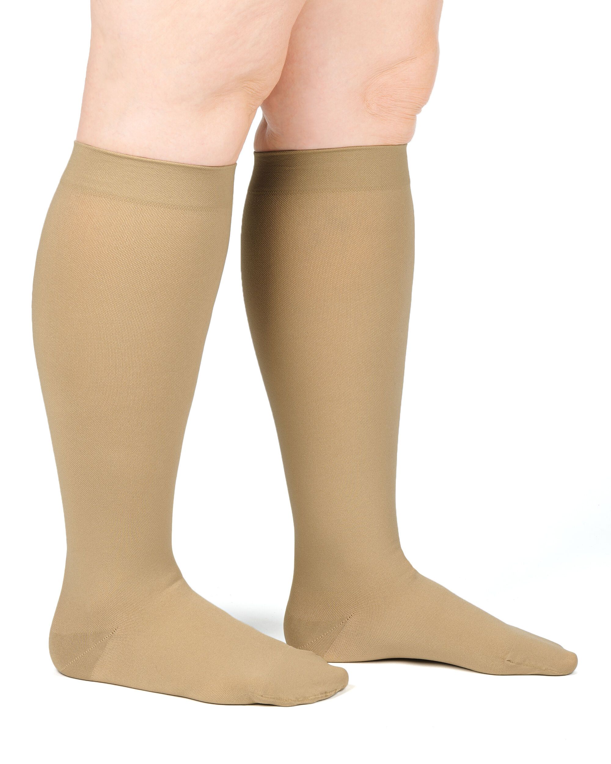 Hautfarbene Kompressions-Kniestrümpfe. Blick von der Seite, an einer Person getragen. Strümpfe reichen bis unterhalb des Knies.