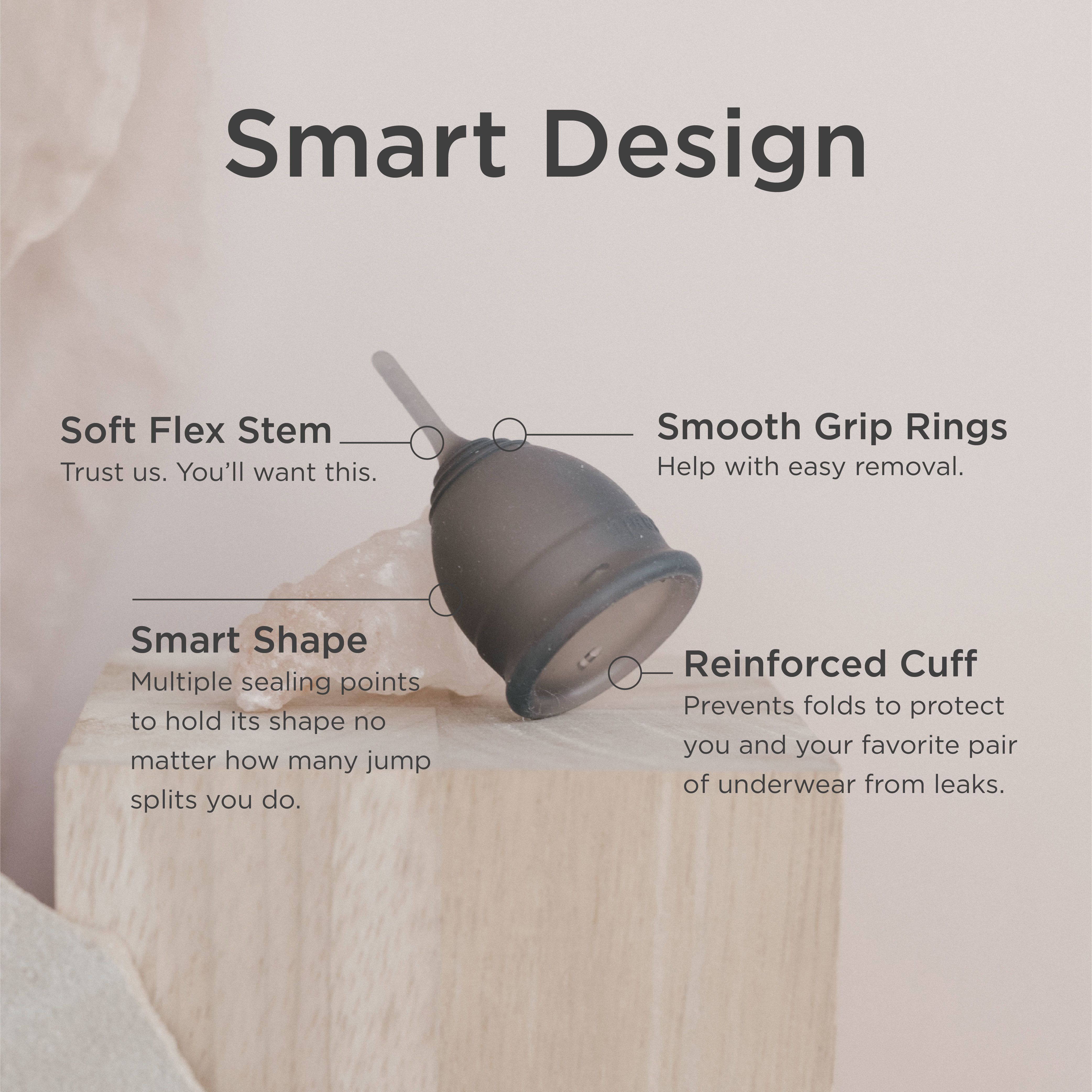 Graue Menstruationstasse mit Beschriftungen: Soft Flex Stem, Smooth Grip Rings, Smart Shape, Reinforced Cuff.