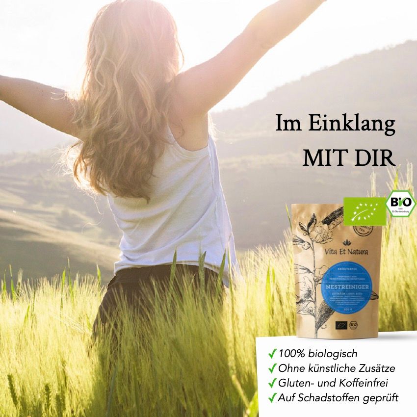 Frau im Feld mit Nestreiniger® Tee-Packung. Text: Im Einklang MIT DIR, 100% biologisch, ohne künstliche Zusätze, gluten- und koffeinfrei.
