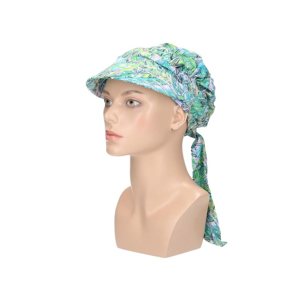 Turban-Cap mit Visier, floralem Muster und Schleife. Auf einer Büste.