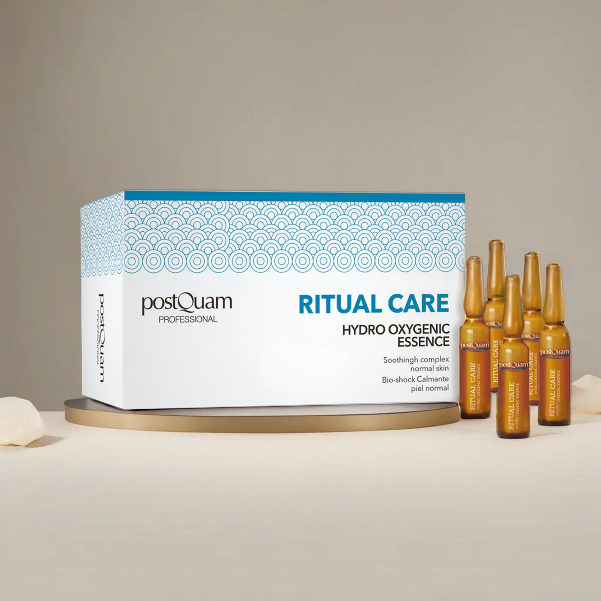 Packung mit Ampullen auf einem Podest. Aufschrift 'Postquam Professional', 'Ritual Care Hydro Oxygenic Essence'. Ampullen daneben.