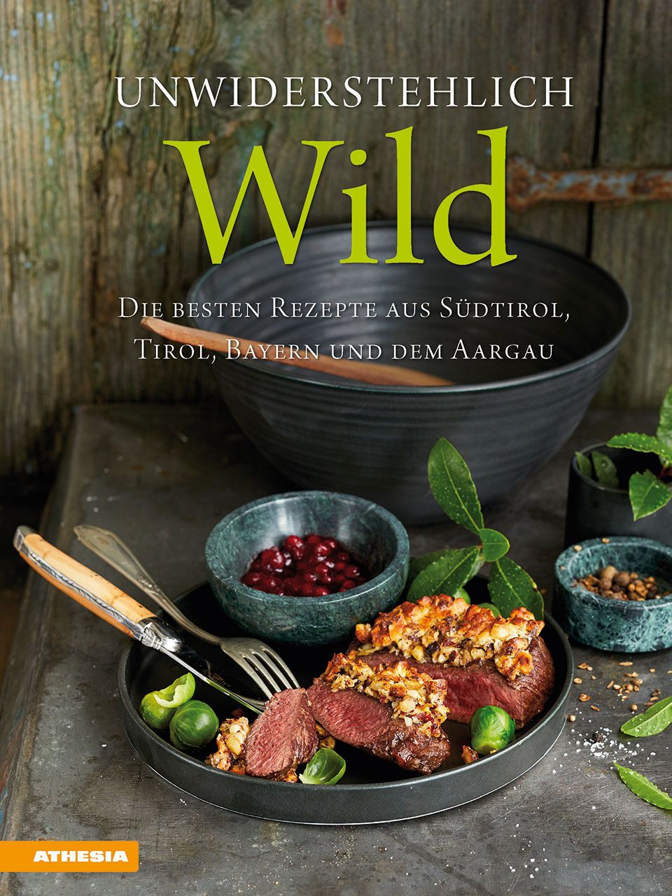 Kochbuch mit dem Titel "Unwiderstehlich Wild". Auf dem Cover sind Wildgerichte und Zutaten abgebildet. Logo: Athesia.