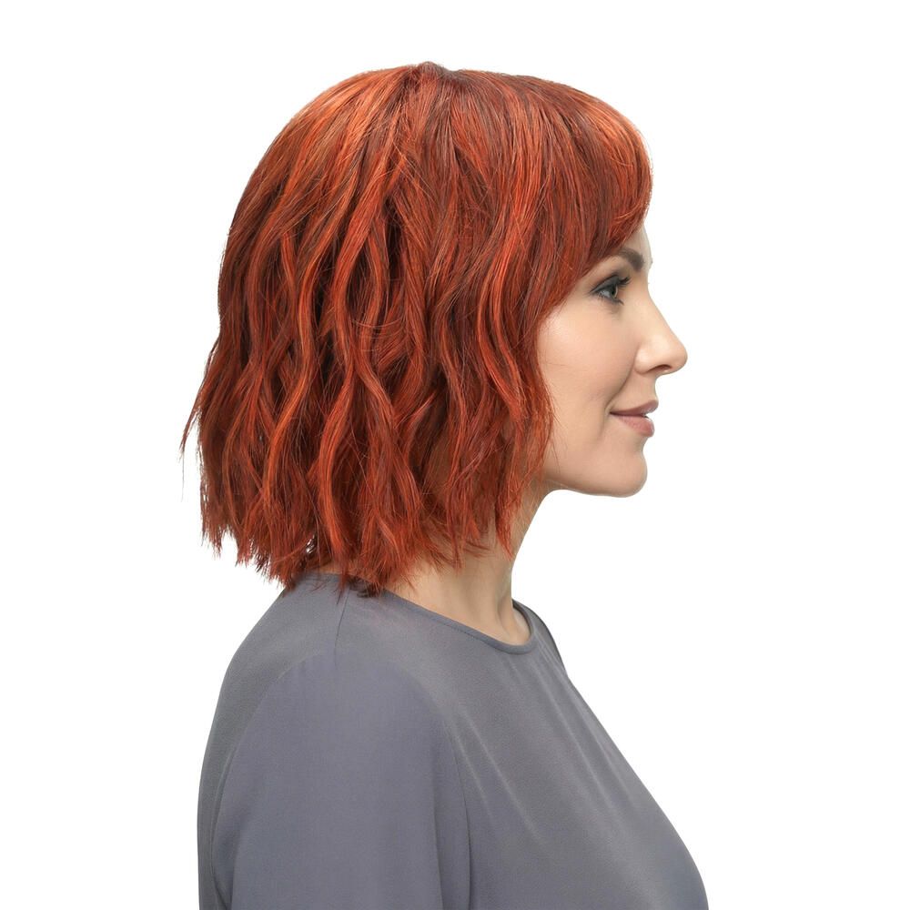 Rote Perücke mit Pony. Die Frau trägt ein graues Oberteil. Seitenansicht.