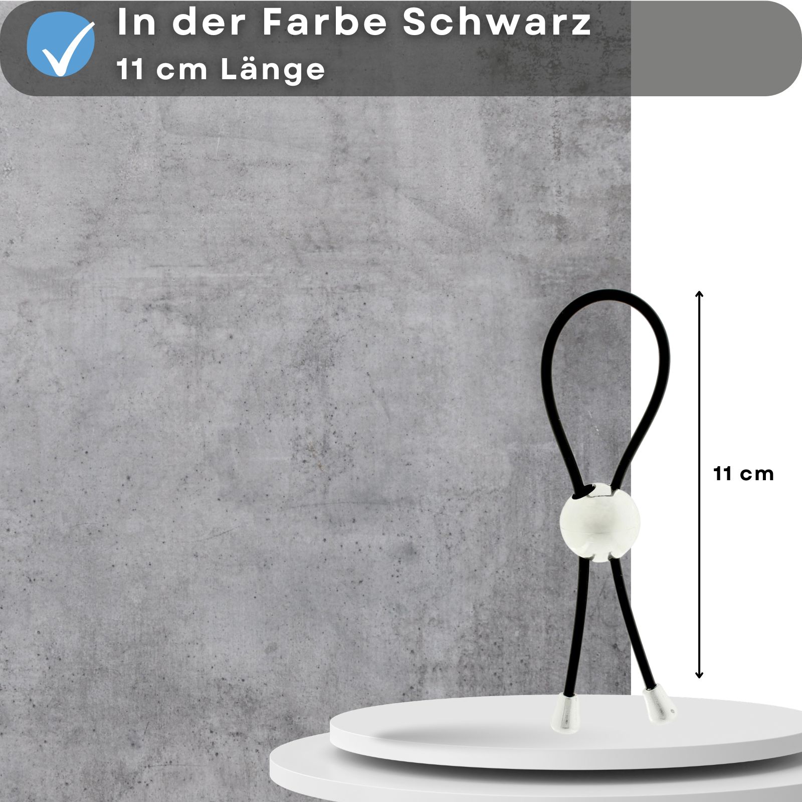Schwarze Silikon-Penisschlaufe mit weißem Kugel-Element. 11 cm lang. Auf Podest vor grauem Hintergrund. Text: Schwarz, 11 cm Länge.