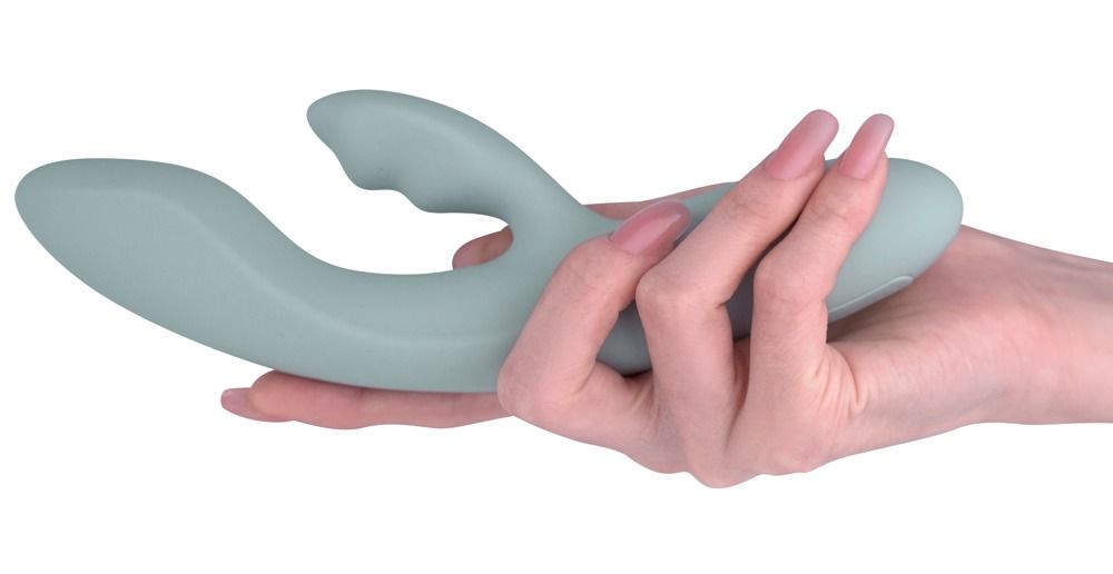 Hellgrauer Vibrator in einer Hand gehalten. Ergonomische Form.