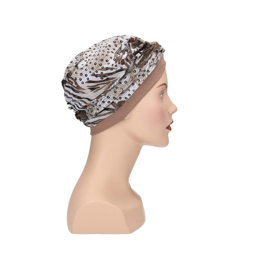 Turban mit Muster auf einer Schaufensterpuppe. Beige Grundfarbe, gemusterter Stoff in Braun- und Beigetönen. Seitenansicht.