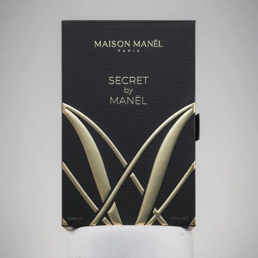 Schwarze Verpackung mit goldener Schrift. Aufschrift "MAISON MANËL PARIS" und "SECRET by MANËL". 50ml e/1.7 FL OZ.