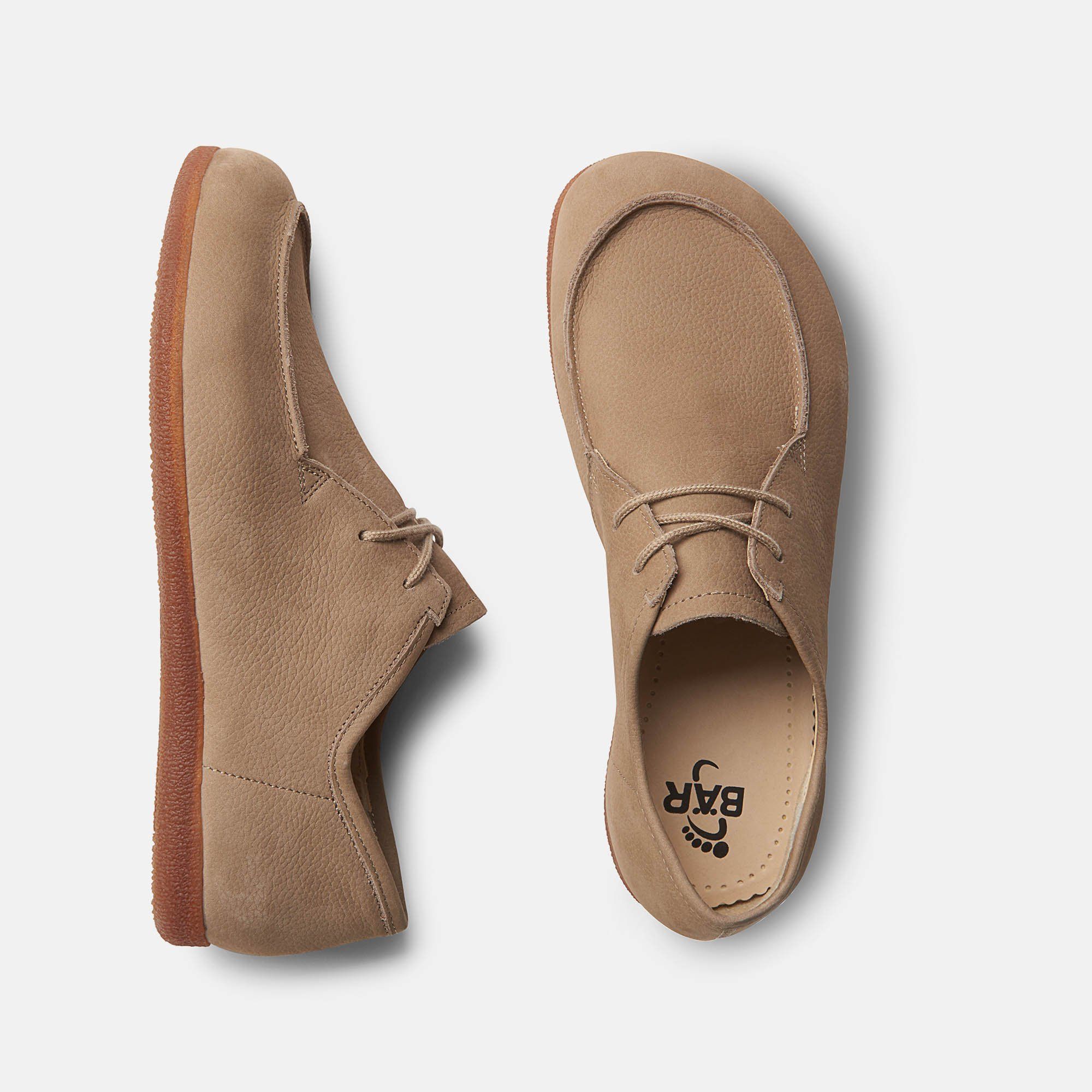 Zwei Schuhe, Draufsicht. Beige Schnürschuhe. Sohle mit Logo. Weite: breit.
