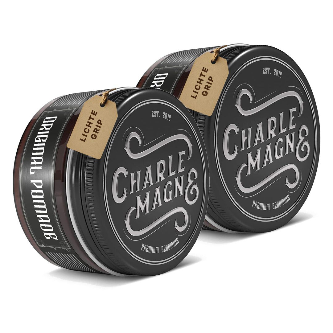 Zwei runde Dosen mit Pomade, "Charle Magn&" und "Original Pomade" Aufschrift.