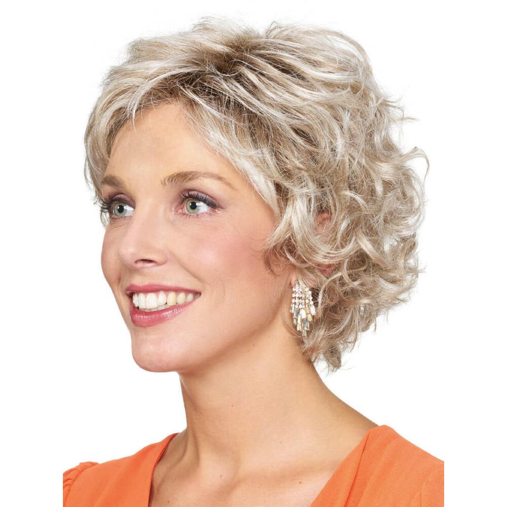 Kurzhaarperücke mit lockigem, blondem Haar. Frau mit orangefarbenem Oberteil. Blick zur Seite.