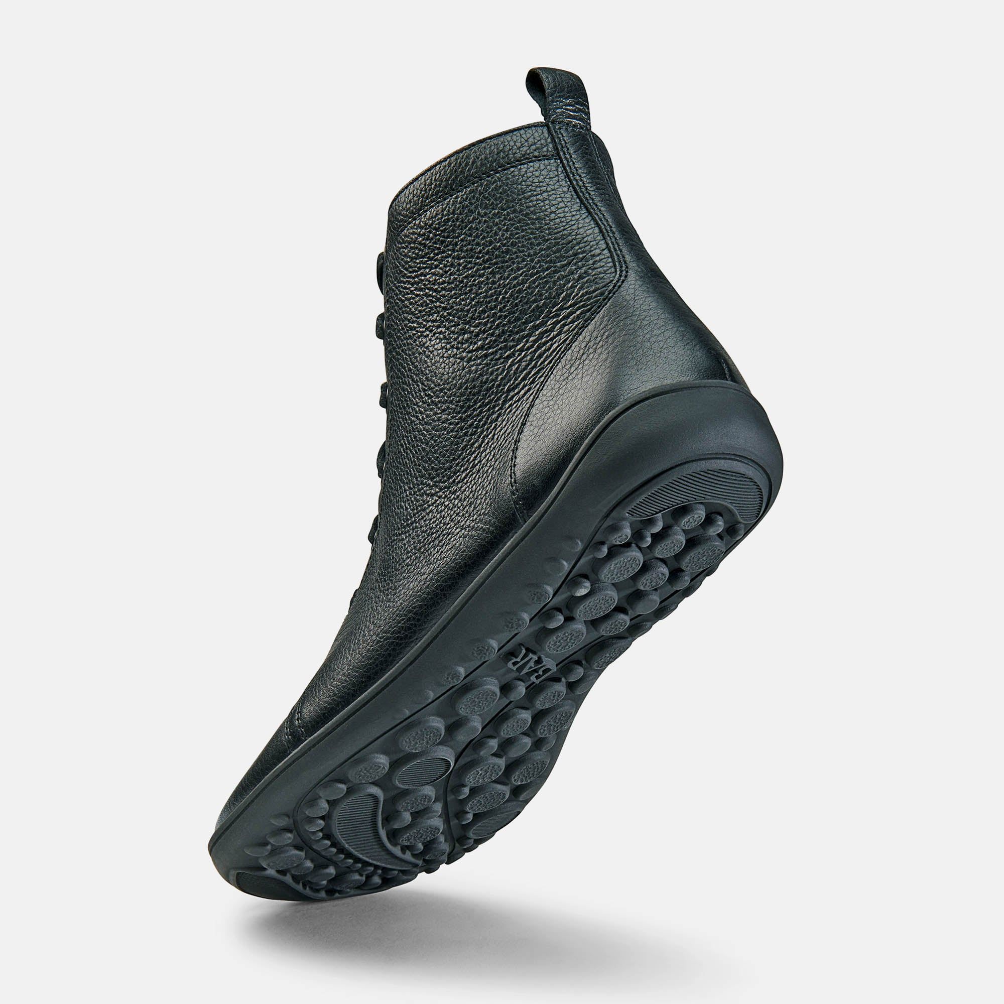 Schwarze Stiefelette, Schnürung, flache Sohle mit Profil. Lederoptik, Schuh von unten, leicht schräg.