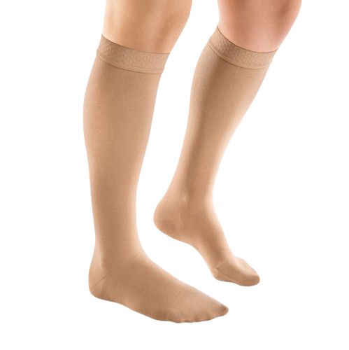 Beige Kompressions-Kniestrümpfe. Blick von der Seite, auf einem weißen Hintergrund. Feine Rippstruktur am oberen Rand.