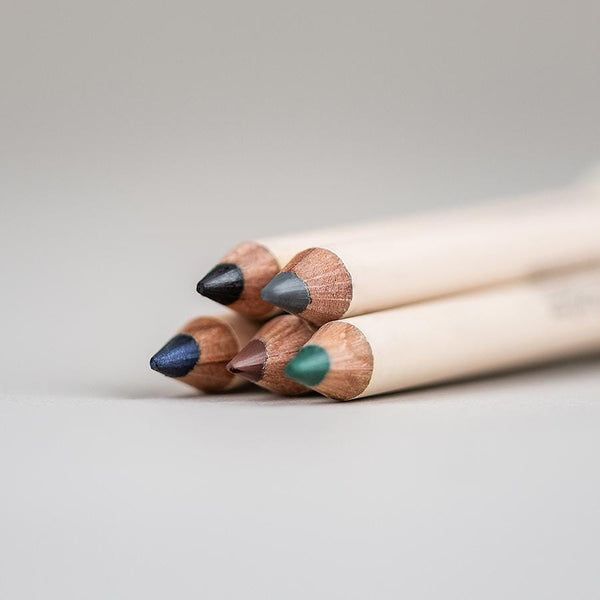 Mehrere Kajalstifte mit farbigen Spitzen. Holzschäfte, verschiedene Farben: Schwarz, Blau, Braun, Grün.