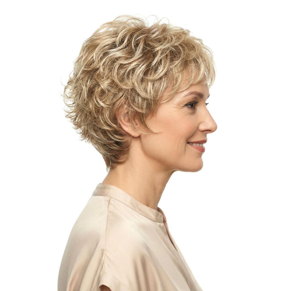 Blonde Kurzhaarperücke. Seitenansicht einer Frau, die die Perücke trägt. Die Perücke hat eine wellige Struktur.