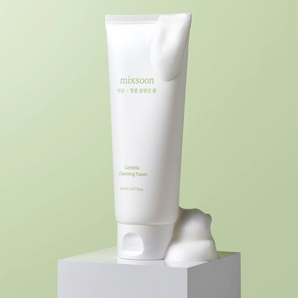 Tube mit Centella Cleansing Foam von mixsoon, mit Schaum auf einem weißen Podest.