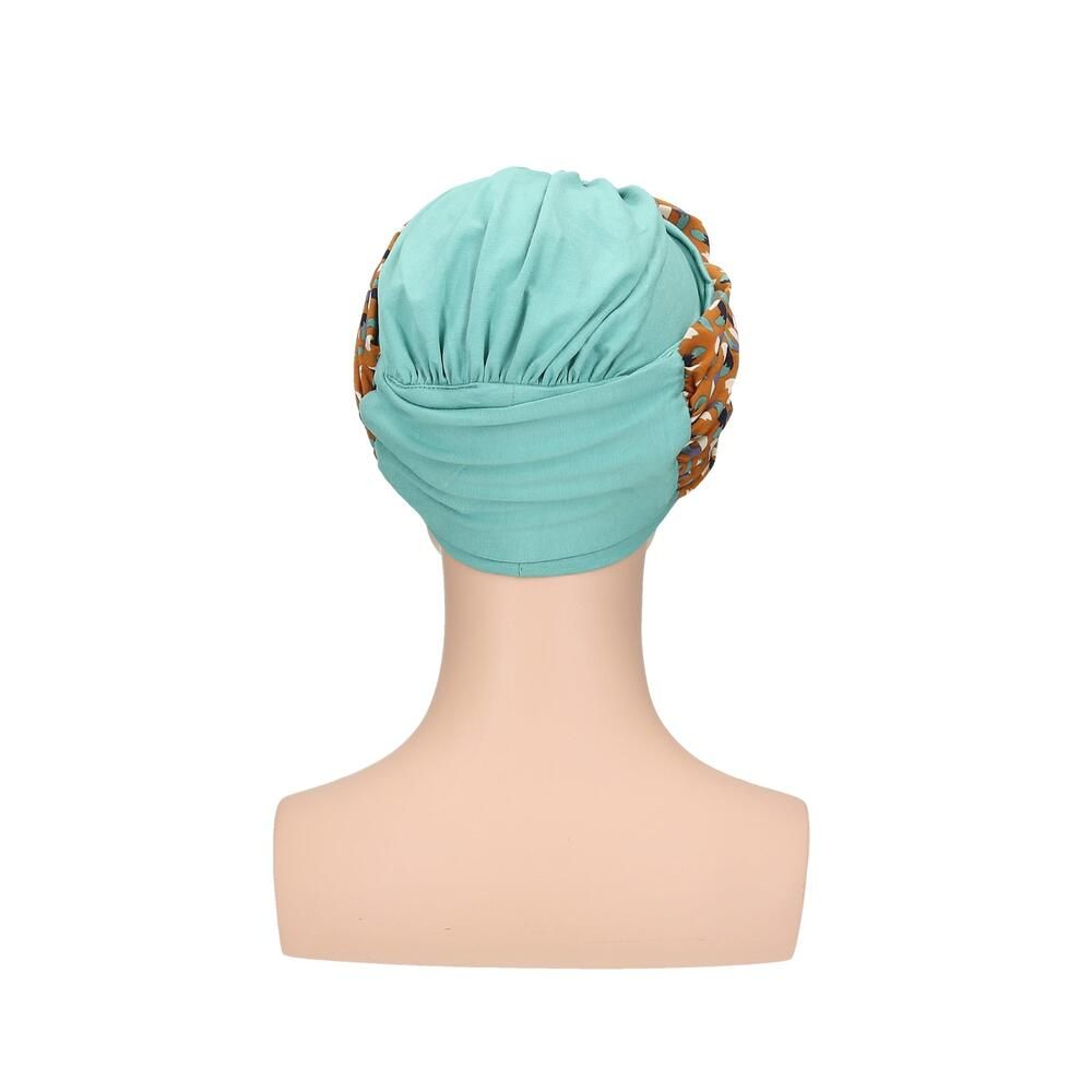 Türkisfarbener Turban mit gemustertem Stirnband auf einer Schaufensterpuppe. Das Stirnband hat ein Muster aus Braun-, Blau- und Beigetönen. Rückansicht.