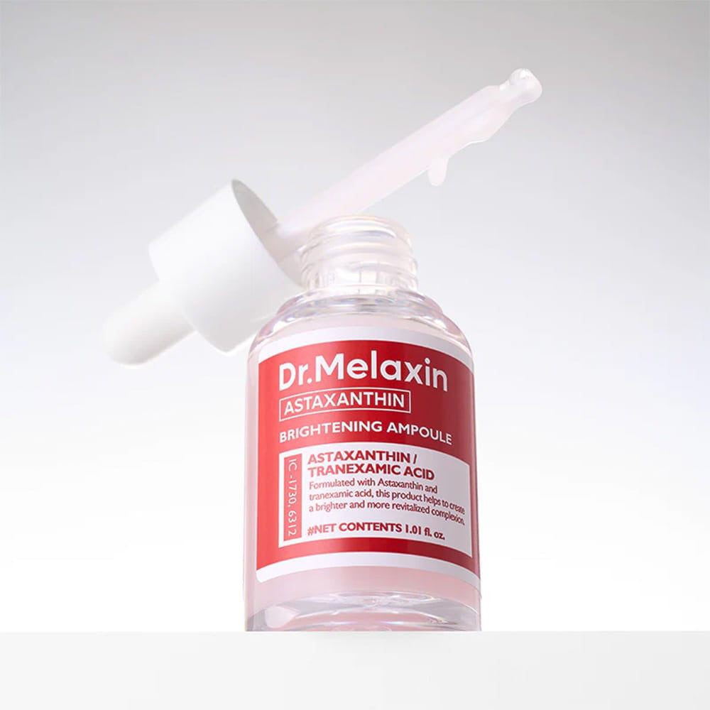 Klare Glasflasche mit weißem Deckel und rotem Etikett. Tropfer im Flaschenhals. Text: Dr. Melaxin, Astaxanthin, Brightening Ampoule.
