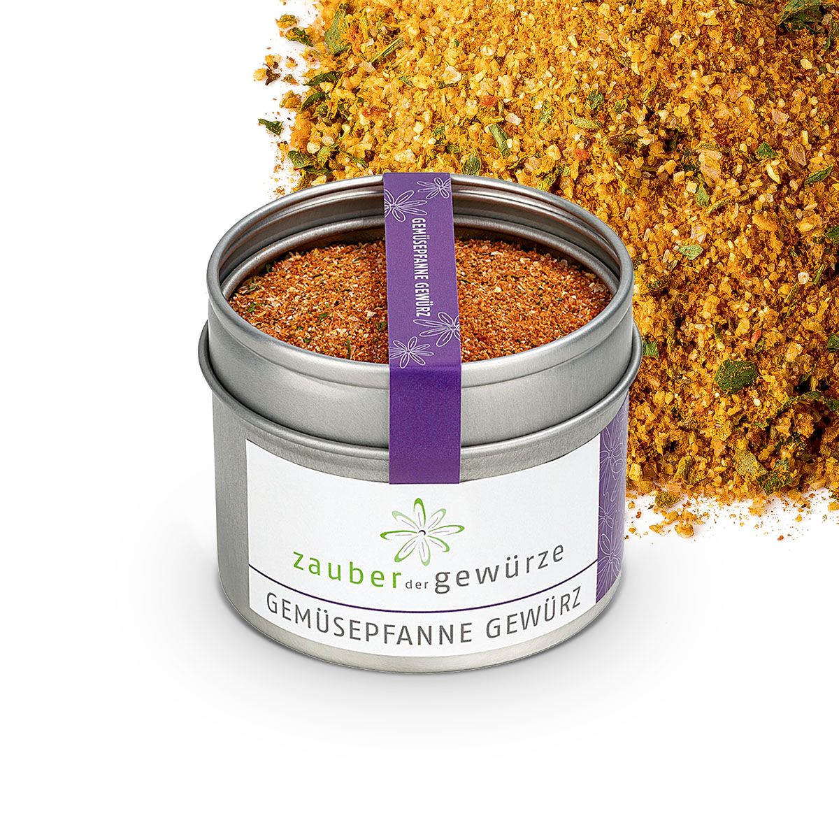 Geöffnete Dose mit Gewürzmischung. Aufschrift: Zauber der Gewürze Gemüsepfanne Gewürz. Lila Band mit Text. Gewürze daneben.