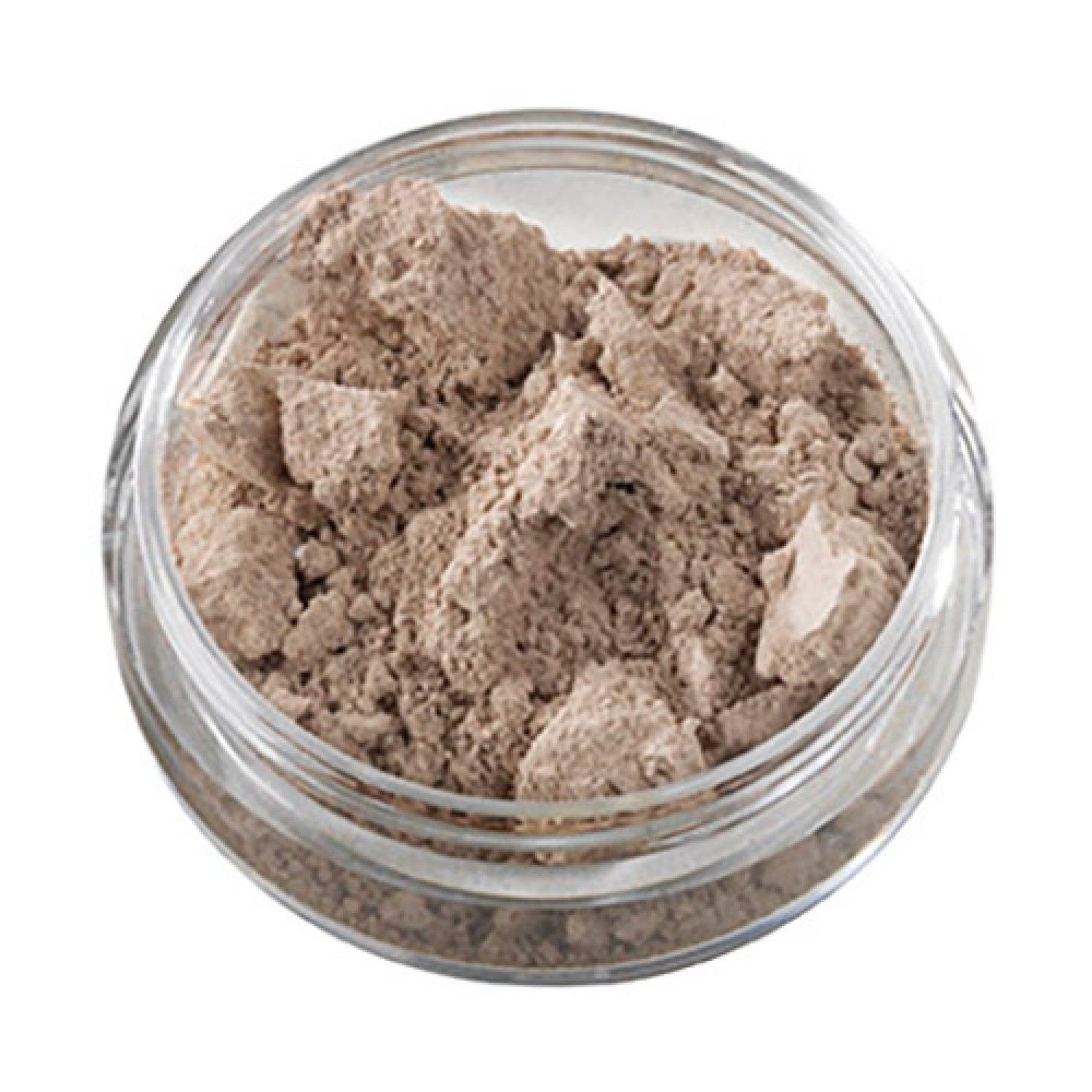 Concealer in rundem, transparentem Tiegel. Inhalt: hellbraunes Puder.