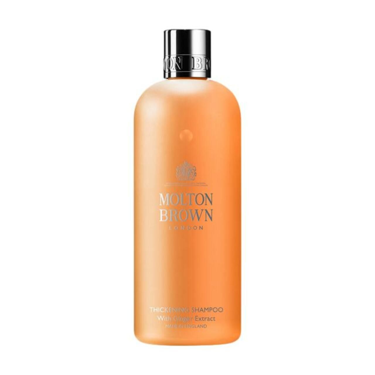 Orangefarbene Shampoo-Flasche mit silbernem Deckel. Schriftzug: Molton Brown London, Thickening Shampoo mit Ingwer Extrakt.