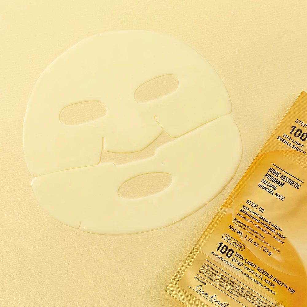 Ein blassgelber Hydrogel-Gesichtsmasken-Bogen mit Augen-, Nasen- und Mundöffnungen, daneben eine passende Verpackung.