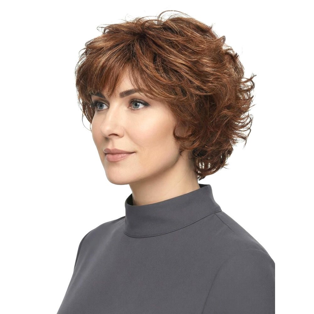 Frau mit roter, gewellter Kurzhaarperücke. Seitenansicht, Blick nach rechts. Graues Oberteil.