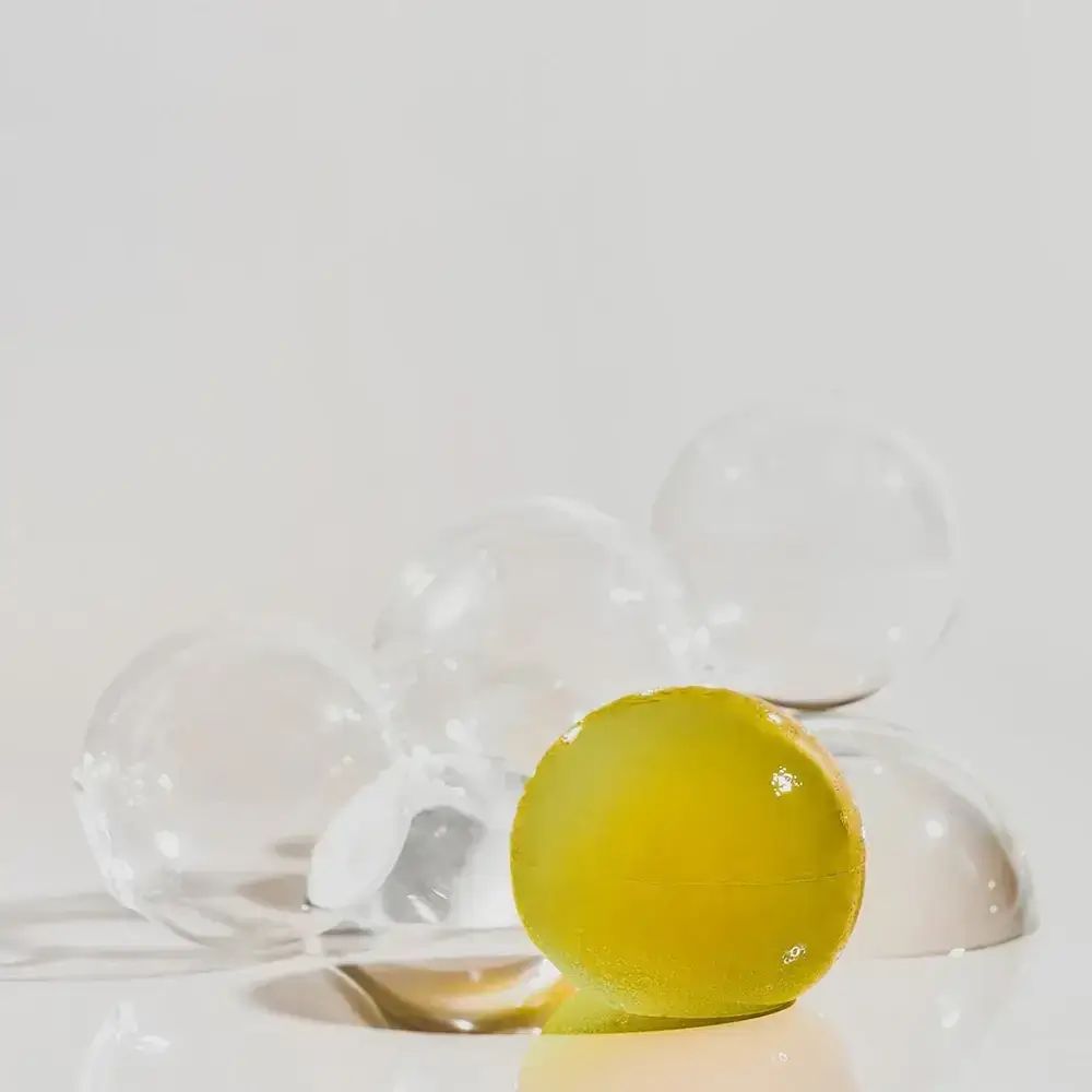 Gelbe Kugel mit anderen transparenten Kugeln. Auf weißem Hintergrund.