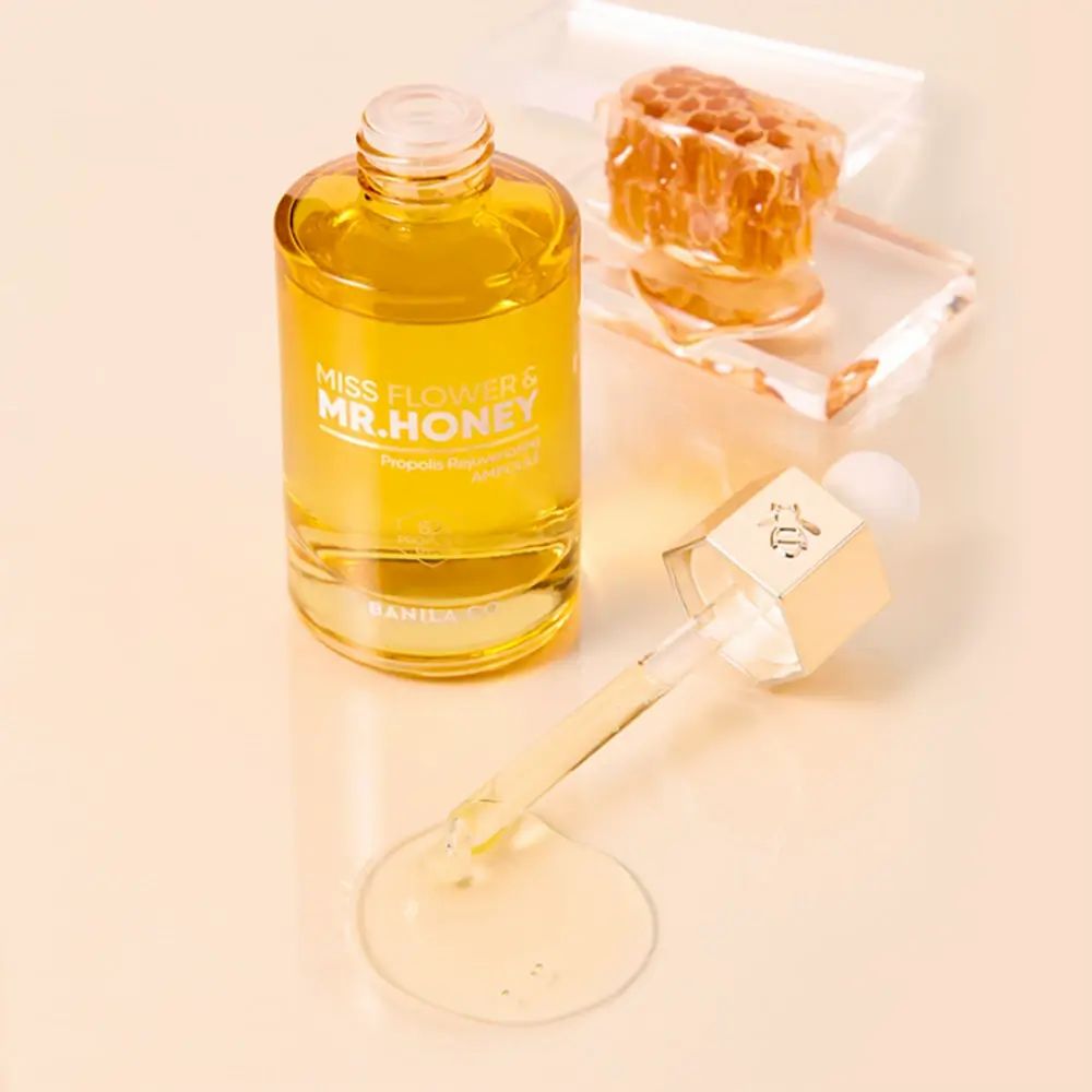 Gesichtsserum-Flasche mit Pipette und Honigwabe. Aufschrift: MISS FLOWER & MR. HONEY. Klare Flüssigkeit.