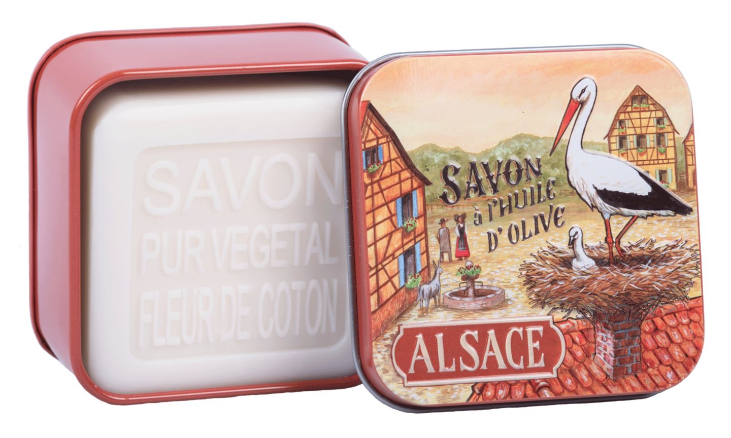 Geöffnete Metallbox mit Seife. Seife mit Schriftzug "SAVON PUR VEGETAL FLEUR DE COTON". Box mit Storch-Motiv.