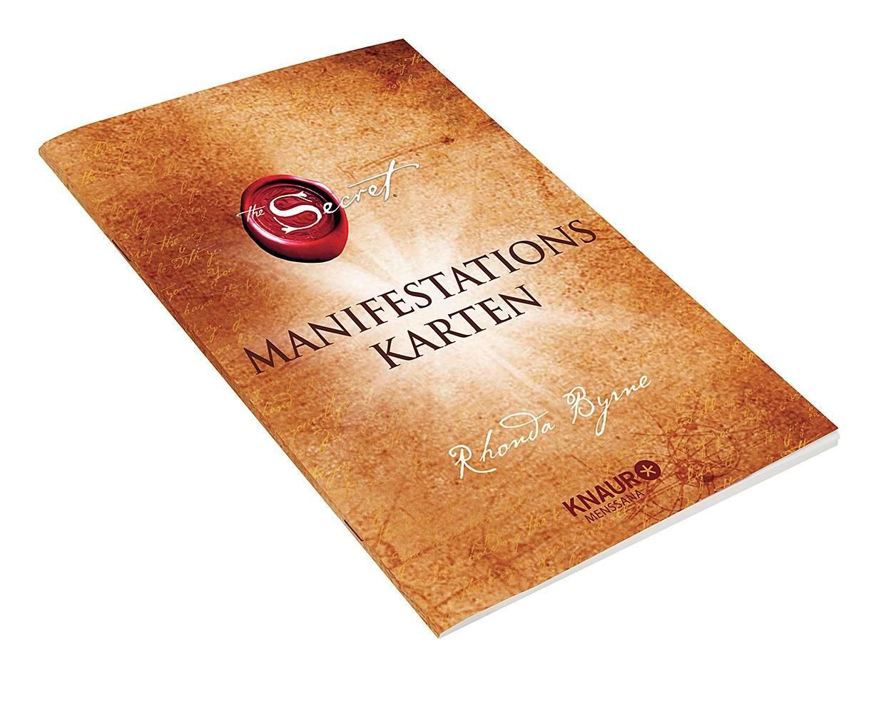 Buch mit dem Titel "Manifestationskarten". Brauner Einband mit rotem Siegel und Text. Autor: Rhonda Byrne.