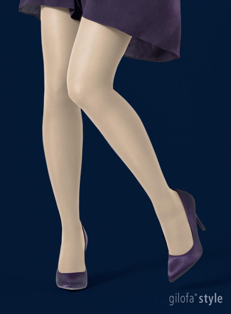 Hautfarbene halterlose Strümpfe. Gilofa Style Logo unten rechts. Frau trägt Schuhe. Auf blauem Hintergrund.