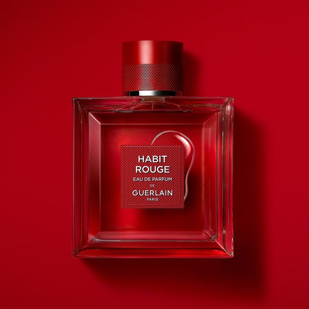 Quadratischer Glasflakon mit rotem Verschluss. Rotes Etikett mit "HABIT ROUGE Eau de Parfum" und "GUERLAIN PARIS". Hintergrund rot.