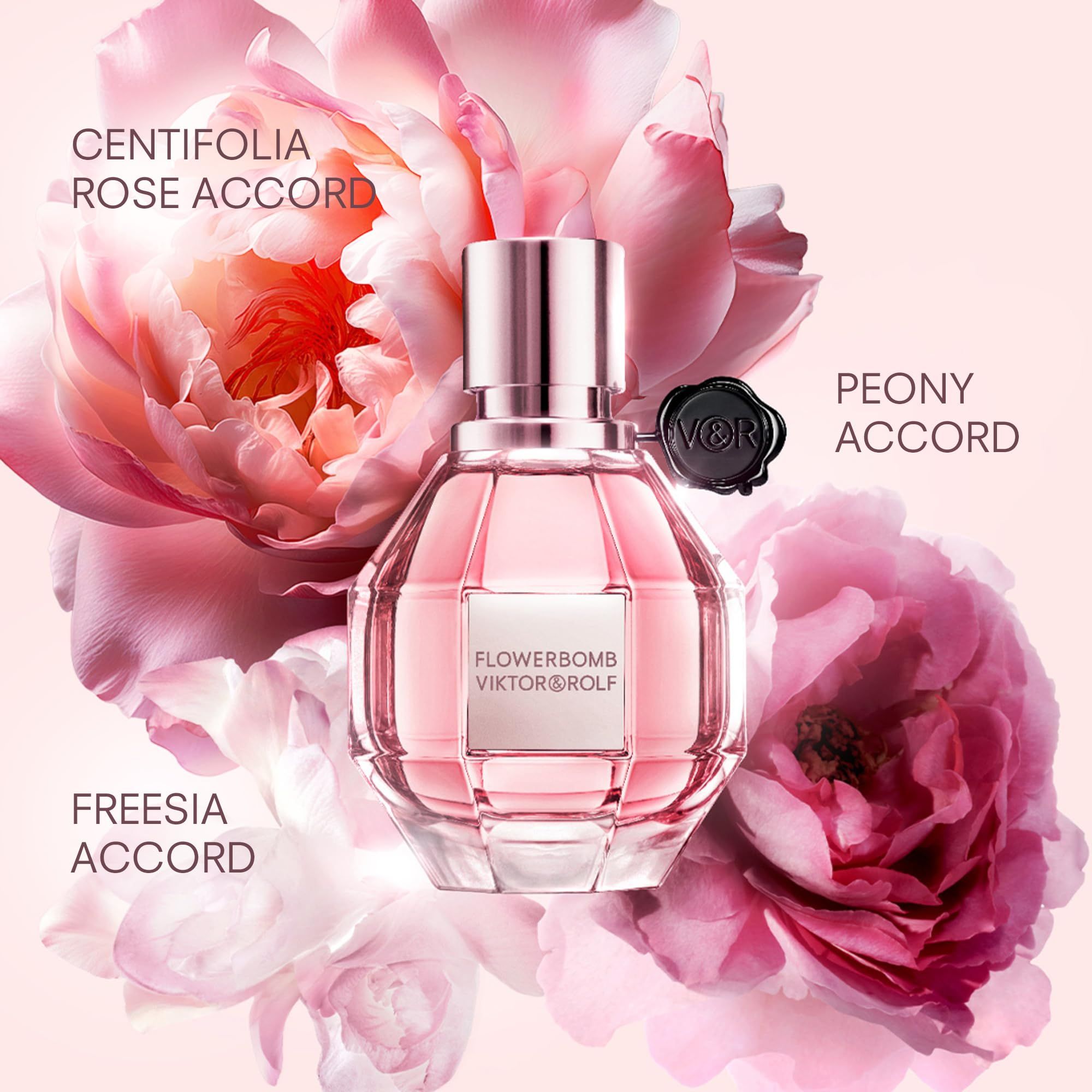 Parfümflakon mit rosafarbenem Inhalt. Aufschrift: Flowerbomb Viktor & Rolf. Blütenhintergrund.