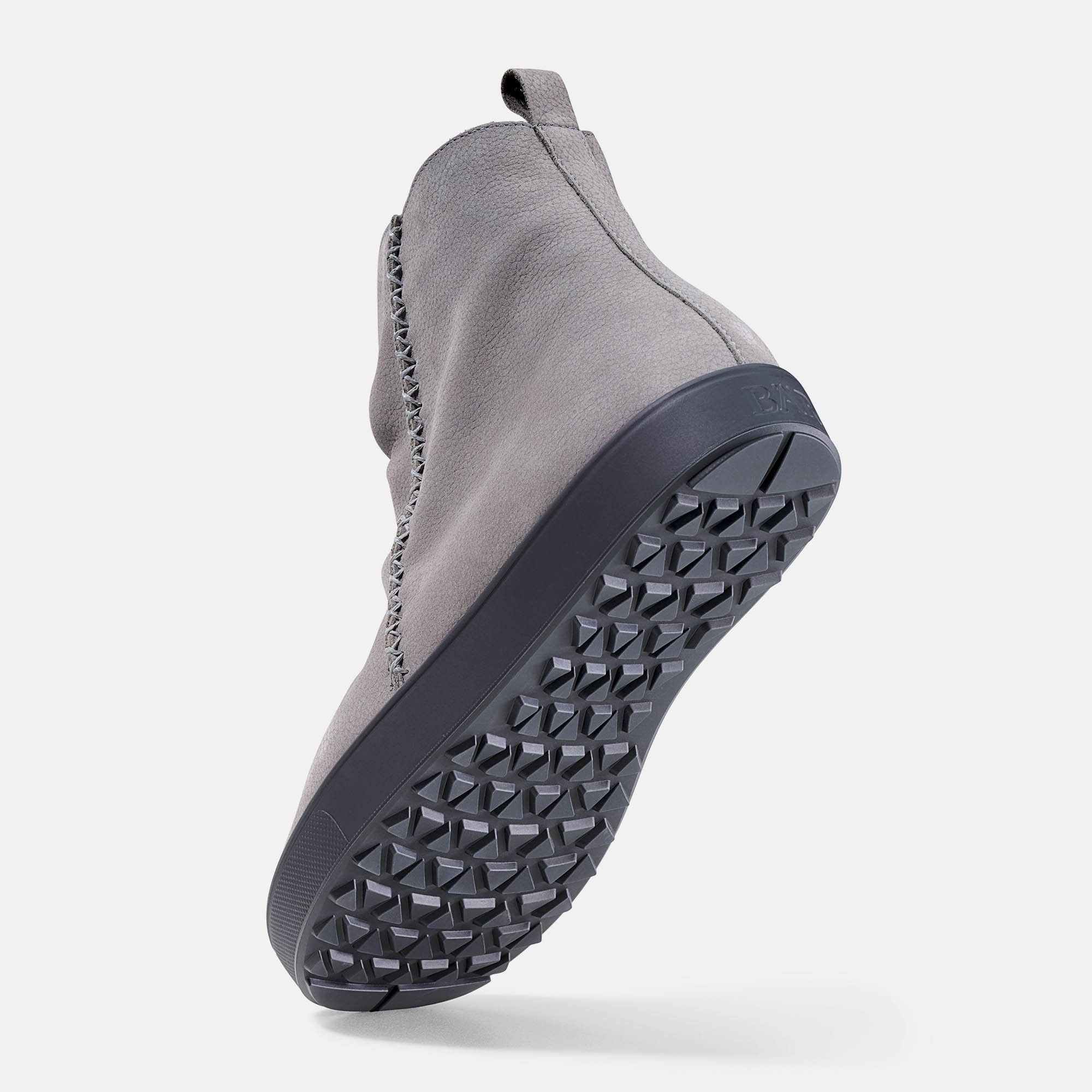 Graue Stiefelette mit breiter Passform. Schwarze Sohle mit Profil. Schuh von unten, leicht erhöht.