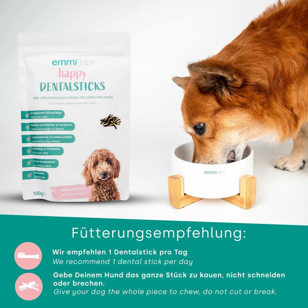 Hund frisst aus Becher. Verpackung mit Dental Sticks. Aufdruck: emmi-pet happy DENTALSTICKS. Text: Fütterungsempfehlung: 1 Dentalstick pro Tag.