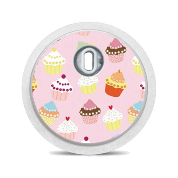 Runder Aufkleber mit Cupcake-Muster. Rosa Hintergrund, Cupcakes in verschiedenen Farben.