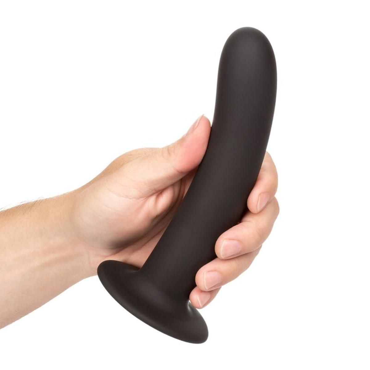 Schwarzer Dildo in einer Hand gehalten. Gebogene Form, breite Basis. Glatte Oberfläche.