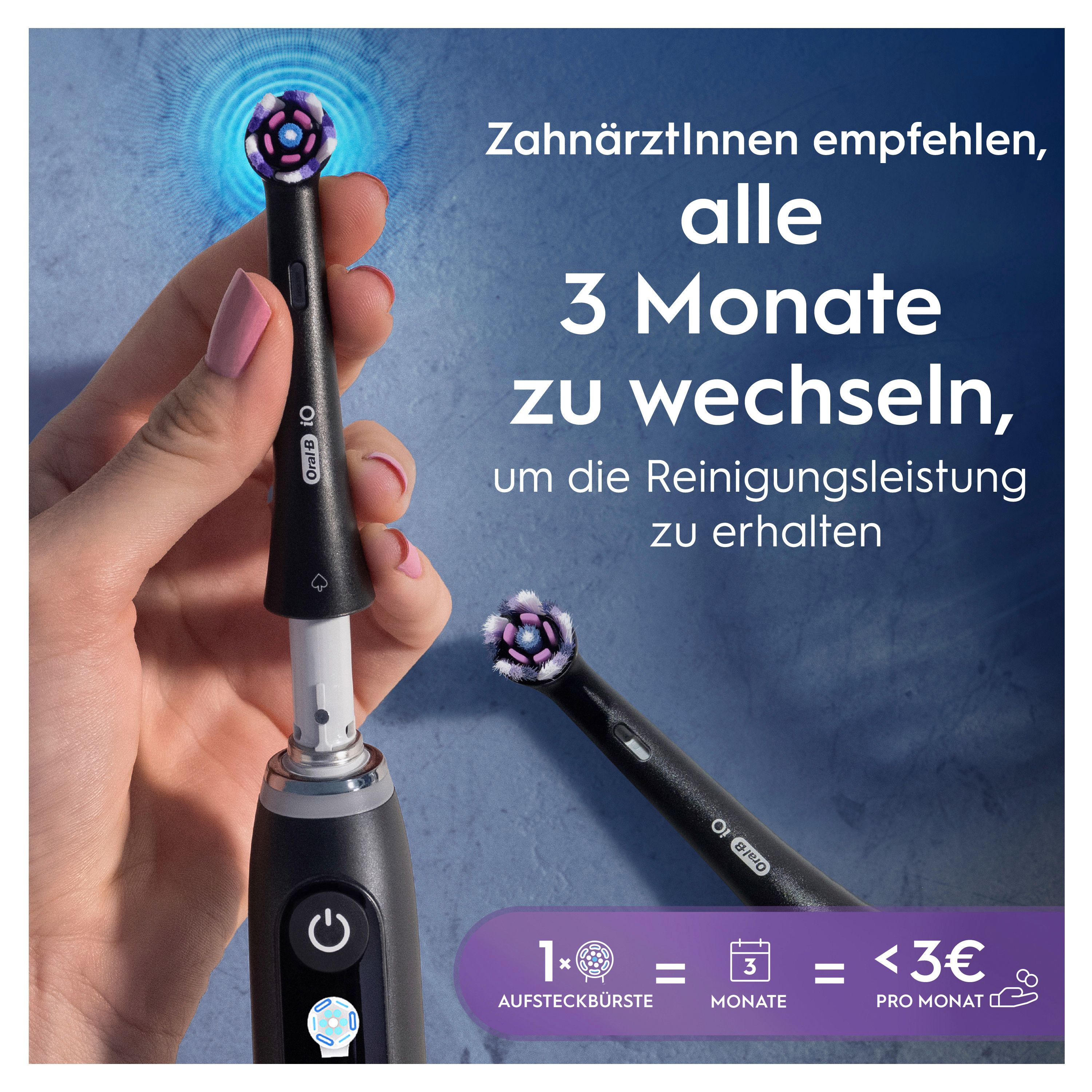 Schwarze elektrische Zahnbürste mit Aufsatz, der gerade eingesetzt wird. Ein weiterer Aufsatz liegt daneben.
