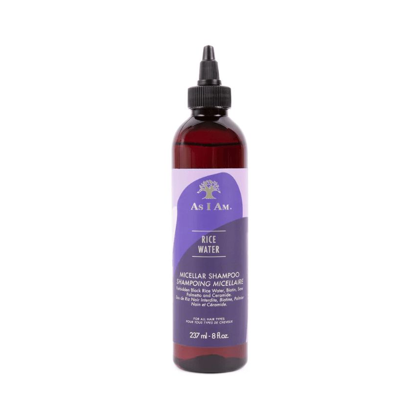 Braune Flasche mit schwarzem Verschluss. Aufkleber mit lila Akzenten und Text: Rice Water Micellar Shampoo. Marke: As I Am.