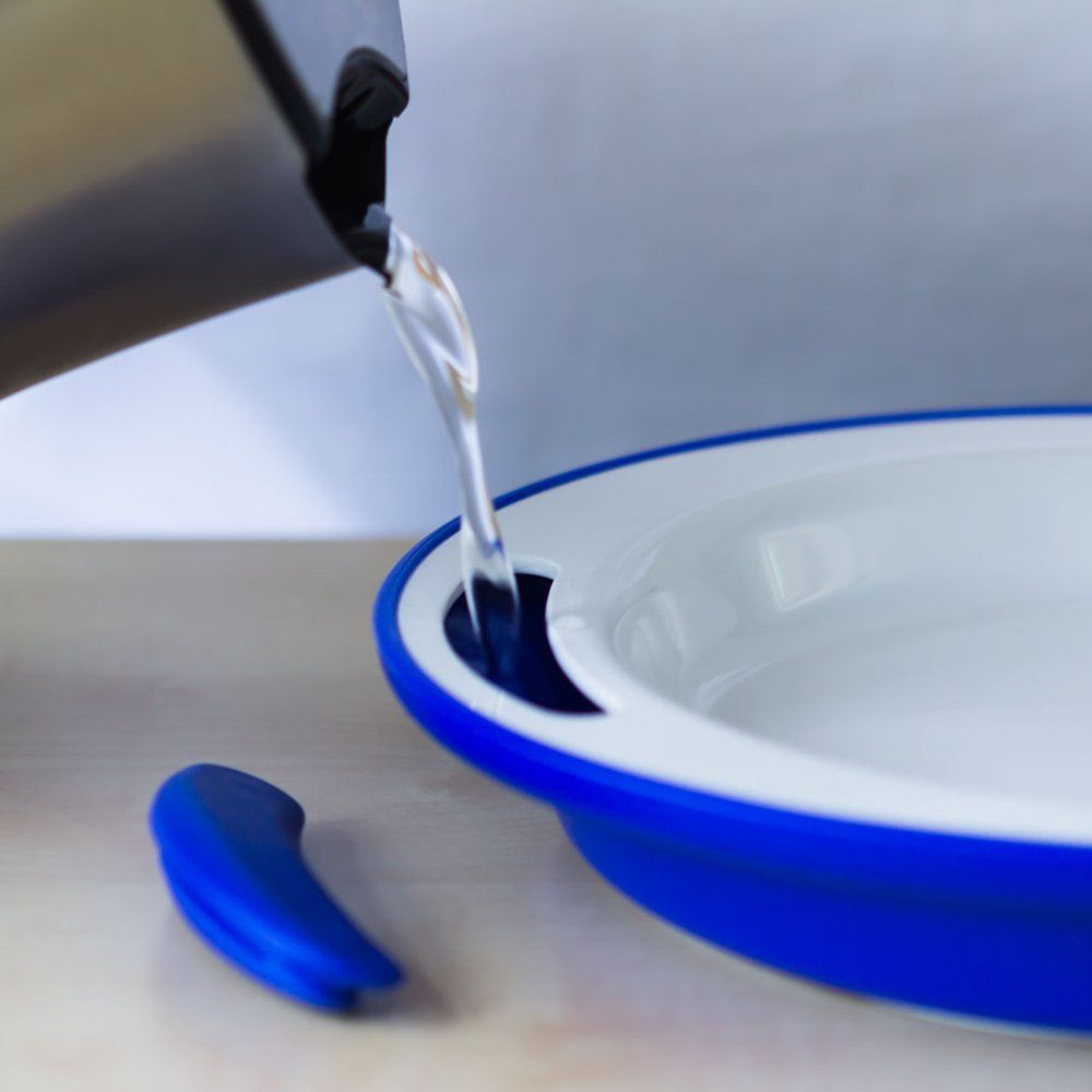 Blauer Teller, Wasser wird aus einem Krug gegossen. Ein Griff liegt daneben.